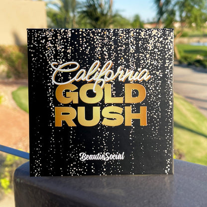 Product packaging with 'California Gold Rush' text on a black background with gold glitter, outdoors.